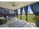 Inviting screened porch with stylish decor, fan, fire pit, and views of the lush backyard and tranquil pond at 120 Haverhill St, Summerville, SC 29486