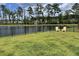 Peaceful backyard featuring a black fence, a serene pond view, and two comfortable Adirondack chairs at 122 Riley Farms Ct, Summerville, SC 29486