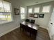 Bright home office with a dark wood desk, and large windows providing ample natural light at 122 Riley Farms Ct, Summerville, SC 29486