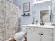 Light blue bathroom with a vanity, modern fixtures, framed art and a shower with a patterned curtain at 1300 Park West Blvd # 512, Mount Pleasant, SC 29466