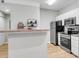 Well-lit kitchen featuring stainless steel appliances, white cabinets, and a breakfast bar for casual dining at 1300 Park West Blvd # 512, Mount Pleasant, SC 29466