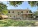 Back exterior of home showing spacious lawn, fenced yard, screened porch and brick patio at 1308 Wild Olive Dr, Mount Pleasant, SC 29464