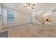 Spacious, carpeted living room with stairs, fireplace, and ceiling fan with plenty of natural light at 1308 Wild Olive Dr, Mount Pleasant, SC 29464