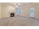 Large, carpeted living room featuring a fireplace, ceiling fan, and access to the backyard at 1308 Wild Olive Dr, Mount Pleasant, SC 29464