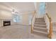 Carpeted living room with a cozy fireplace, ceiling fan, and staircase at 1308 Wild Olive Dr, Mount Pleasant, SC 29464