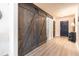Hallway featuring wood floors, a dark sliding barn door, and an entryway with a black front door at 137 Salem Creek Dr, Goose Creek, SC 29445