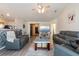 Spacious living room featuring gray leather furniture, a fan, and a brick accent wall for a modern look at 137 Salem Creek Dr, Goose Creek, SC 29445