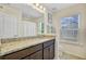 Bright bathroom featuring a granite vanity top, modern lighting, and a window for natural light at 142 Elliott Creek Ln, Summerville, SC 29485