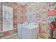 Vibrant laundry room showcasing patterned wallpaper and modern side-by-side washer and dryer at 142 Elliott Creek Ln, Summerville, SC 29485