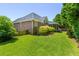Spacious backyard with green grass, mature trees, and brick house at 1441 Waterside Ct, Mount Pleasant, SC 29464
