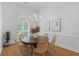 Dining area with wood table, rattan chairs, chandelier, art, and view to the outside at 1441 Waterside Ct, Mount Pleasant, SC 29464
