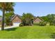 Brick home featuring manicured lawn, mature landscaping, attached garage, and a classic architectural design at 1441 Waterside Ct, Mount Pleasant, SC 29464