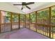 Inviting screened porch featuring wood flooring, ceiling fan, and wooded backyard view at 1441 Waterside Ct, Mount Pleasant, SC 29464
