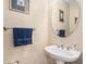 Half bathroom featuring a pedestal sink, round mirror, and towel rack at 145 Pier View St # 111, Charleston, SC 29492
