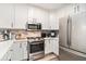 Bright white kitchen with stainless steel appliances and marble backsplash at 145 Pier View St # 111, Charleston, SC 29492