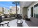 Condo patio featuring wicker furniture, a small table, and a serene outdoor view with a palm tree and American flag at 145 Pier View St # 111, Charleston, SC 29492