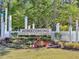 Landscaped entrance to the Homecoming community with white fencing and a colorful welcome sign at 1541 Homecoming Blvd, Ravenel, SC 29470