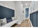 Hallway with blue accent wall, coat hooks, bench with pillows, and access to other rooms at 1541 Homecoming Blvd, Ravenel, SC 29470