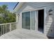 Bright balcony with sliding glass doors, lantern sconces, and white wooden railing offering a tranquil outdoor retreat at 1551 Ben Sawyer Blvd # 4D, Mount Pleasant, SC 29464