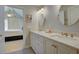 Bathroom showcasing a double vanity with marble countertop, oval mirrors, and direct access to the bedroom at 1551 Ben Sawyer Blvd # 4D, Mount Pleasant, SC 29464