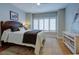 Brightly lit bedroom with white plantation shutters, area rug and wooden queen bed with a padded headboard at 1551 Ben Sawyer Blvd # 4D, Mount Pleasant, SC 29464