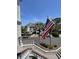 View of a property with an American flag, palm trees, and a coastal-style facade at 1551 Ben Sawyer Blvd # 4D, Mount Pleasant, SC 29464