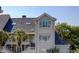 Charming multi-story beach condo featuring bright exteriors, multiple windows, and a rooftop balcony with palm tree views at 1551 Ben Sawyer Blvd # 4D, Mount Pleasant, SC 29464