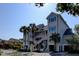 Exterior view of a multi-story condo with stairs, palm trees, and beautiful landscaping on a sunny day at 1551 Ben Sawyer Blvd # 4D, Mount Pleasant, SC 29464