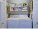 Laundry room with white washer and dryer, storage shelves, overhead lighting and utility sink at 1551 Ben Sawyer Blvd # 4D, Mount Pleasant, SC 29464
