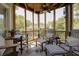 Comfortable screened porch with wood ceiling, ceiling fan, and comfortable seating area with decorative rug at 1551 Ben Sawyer Blvd # 4D, Mount Pleasant, SC 29464