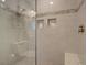 Close-up of a shower featuring a glass enclosure, tiled walls, mosaic accents, and built-in shelving at 1551 Ben Sawyer Blvd # 4D, Mount Pleasant, SC 29464