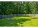 Spacious backyard with a lush lawn, mature trees, and a fire pit, perfect for outdoor enjoyment at 1607 Roustabout Way, Charleston, SC 29414