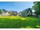 Expansive backyard featuring a fire pit, lush green lawn, and mature trees creating a serene setting at 1607 Roustabout Way, Charleston, SC 29414