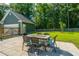 A backyard patio with a table and chairs overlooks a spacious green lawn and fenced perimeter at 1607 Roustabout Way, Charleston, SC 29414