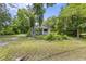 Lovely single-story home featuring a cozy covered porch, framed by mature trees and a lush green lawn at 1736 Central Ave, Summerville, SC 29483