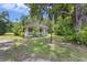 Inviting single-story home with a covered porch, lush green lawn, and mature trees offering a serene setting at 1736 Central Ave, Summerville, SC 29483
