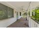 Covered front porch featuring weathered wood floors, white columns, a ceiling fan, and a light blue front door at 1736 Central Ave, Summerville, SC 29483