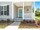 Inviting front porch features a teal door, charming round window, and well-maintained landscaping at 1844 Hubbell Dr, Mount Pleasant, SC 29466
