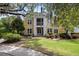 Inviting yellow two-story home with a screened porch, surrounded by lush landscaping and mature trees at 1915 Chatelain Way, Mount Pleasant, SC 29464