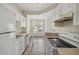 Functional kitchen features white appliances, ample cabinetry, and sleek wood flooring, ideal for cooking at 1915 Chatelain Way, Mount Pleasant, SC 29464