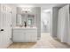 Bright bathroom featuring double vanity, framed mirrors, updated lighting, and beige tile flooring at 2009 Arundel Pl, Mount Pleasant, SC 29464