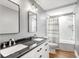 Bathroom features double vanity with dark countertop, framed mirrors, and shower over tub with white marbled walls at 2009 Arundel Pl, Mount Pleasant, SC 29464