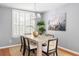 Chic dining area with stylish chandelier, shuttered windows, and seating for six guests at 2009 Arundel Pl, Mount Pleasant, SC 29464
