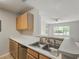 Kitchen counter with stainless steel sink, wood cabinets, and a view of the living room at 2011 N Highway 17 # 1400P, Mount Pleasant, SC 29466