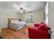 Bright bedroom with hardwood floors, ceiling fan, and a cozy red couch at 2021 Lakeshore Dr, Charleston, SC 29412