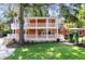 Charming two-story home boasts a double porch and lush landscaping, creating a welcoming curb appeal at 2021 Lakeshore Dr, Charleston, SC 29412