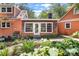Charming exterior detail with a mix of brick and wood, complemented by a garden and lush plants at 2021 Lakeshore Dr, Charleston, SC 29412