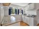 Close up of a kitchenette with stainless steel sink, cooktop, and refrigerator with white cabinets at 2021 Lakeshore Dr, Charleston, SC 29412