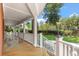 Covered porch with white columns and railing offering views of the landscaped yard at 2021 Lakeshore Dr, Charleston, SC 29412