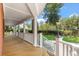 Inviting covered porch with classic white railings and columns, offering a perfect spot for relaxation at 2021 Lakeshore Dr, Charleston, SC 29412
